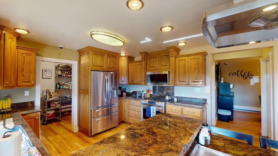 Large kitchen has gas range, French door fridge, microwave, granite counters