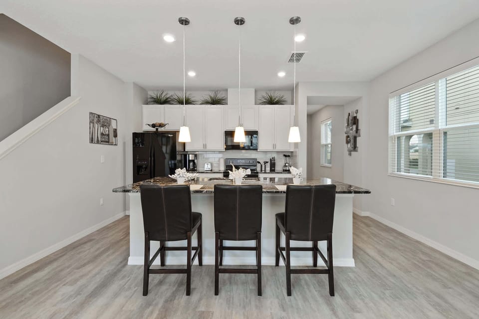 Bright living area with a white sectional, modern decor, and dining nook-great for relaxed family gatherings.