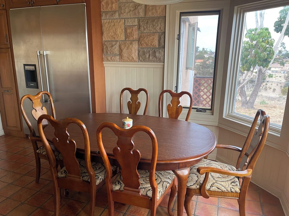 Dining table in the kitchen. Oversized fridge.