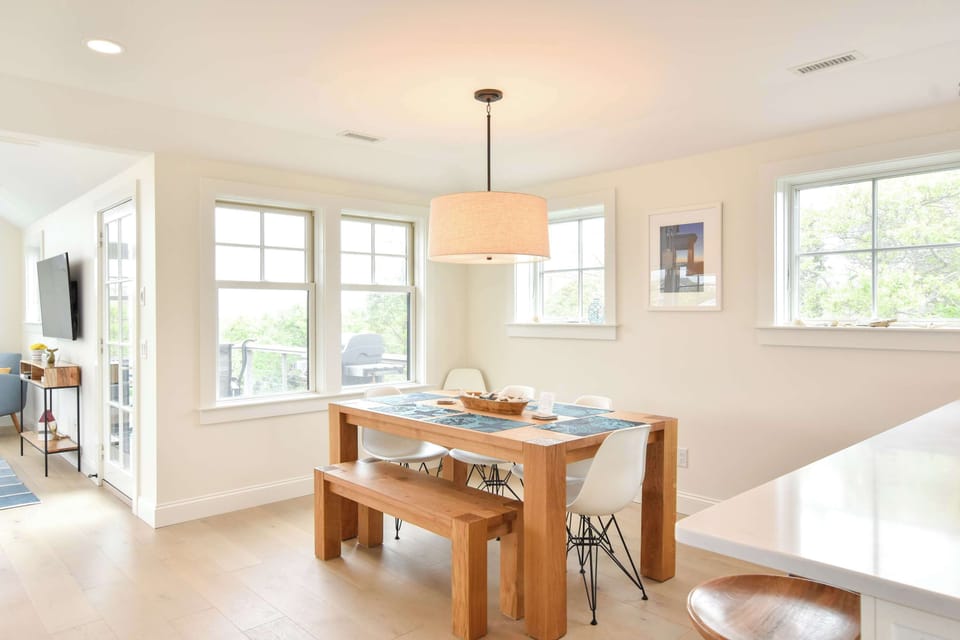 dining room table with seating bench and white chairs
