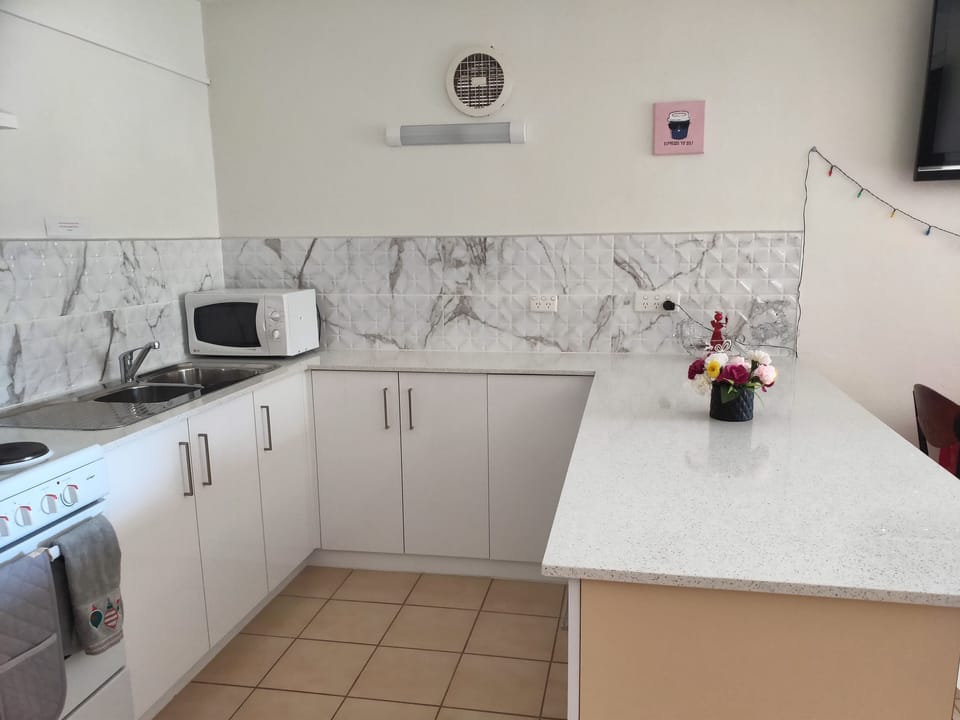 Fully equipped kitchen with microwave, oven,
 rice cooker and kitchen utensils
