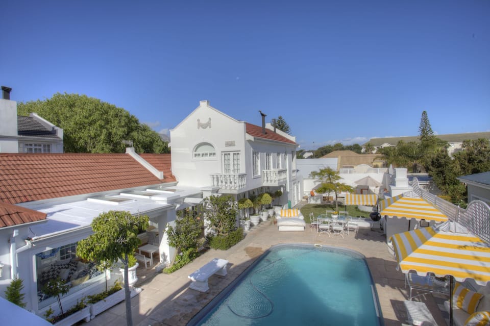 Birds eye view of the pool area, 8 chaizes, dining table outside barbeque