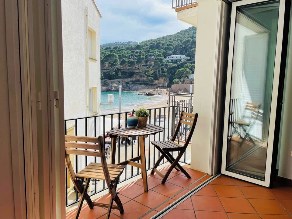 Enjoy breathtaking views of Tamariu Beach and the surrounding hills from your private balcony. Open the sliding glass doors to seamlessly blend indoor and outdoor living, creating the perfect setting for a relaxing beach getaway.