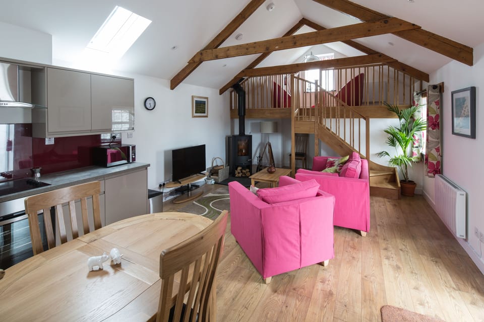 A view of the living area, woodburner and mezzanine from the bedroom door