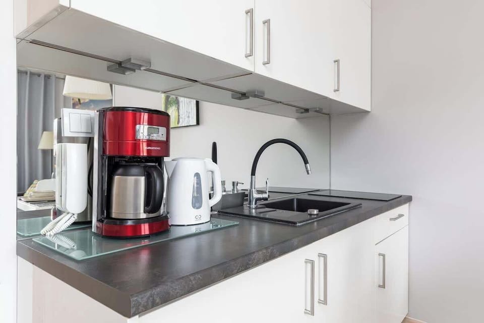 Close-up of the coffee machine and electric kettle on the grey countertop.