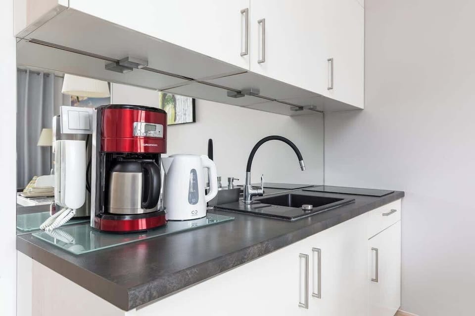 Close-up of the coffee machine and electric kettle on the grey countertop.
