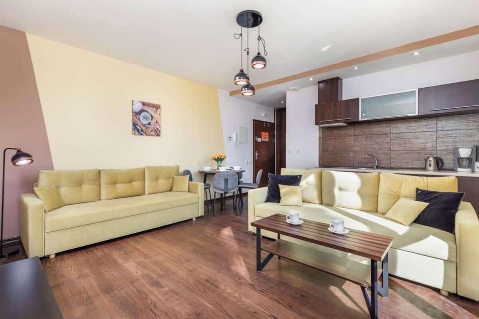 A living room featuring a large window and a cozy seating area, filling the room with natural light.