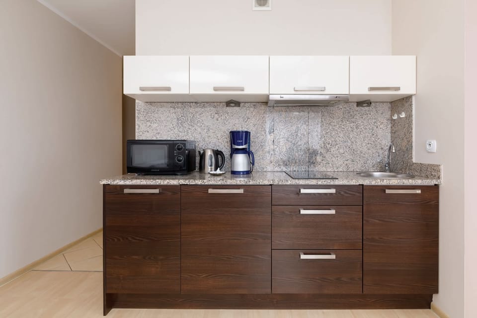 Kitchenette with coffee machine and refrigerator. 