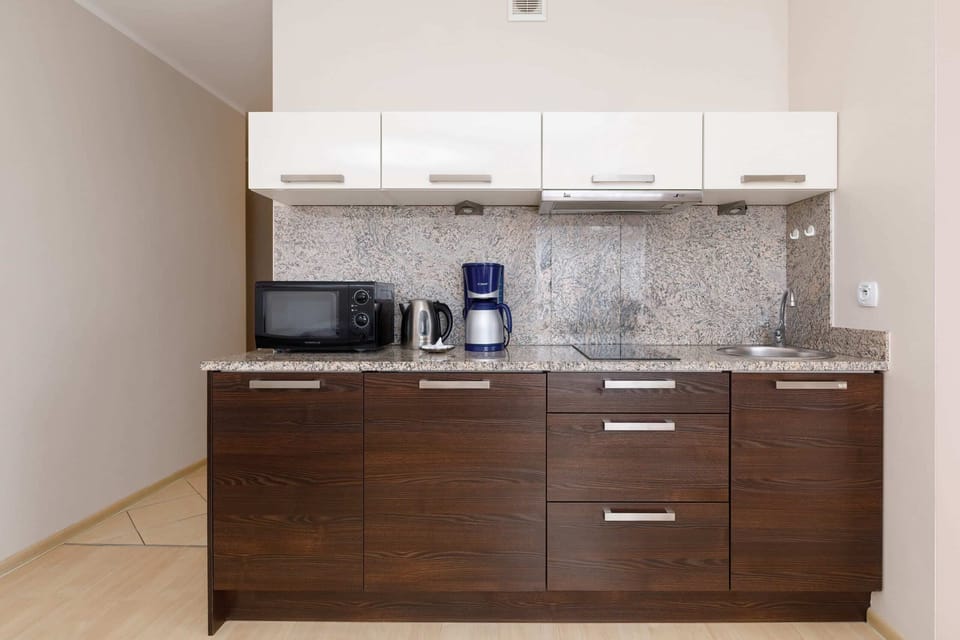 Kitchenette with coffee machine and refrigerator. 