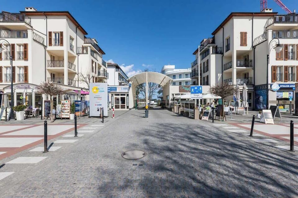 A street scene with people walking, showcasing the proximity to local shops or a bustling neighborhood. This image highlights the lively atmosphere around the apartment.