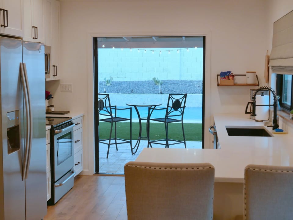 Open concept kitchen with french doors leading out to pool