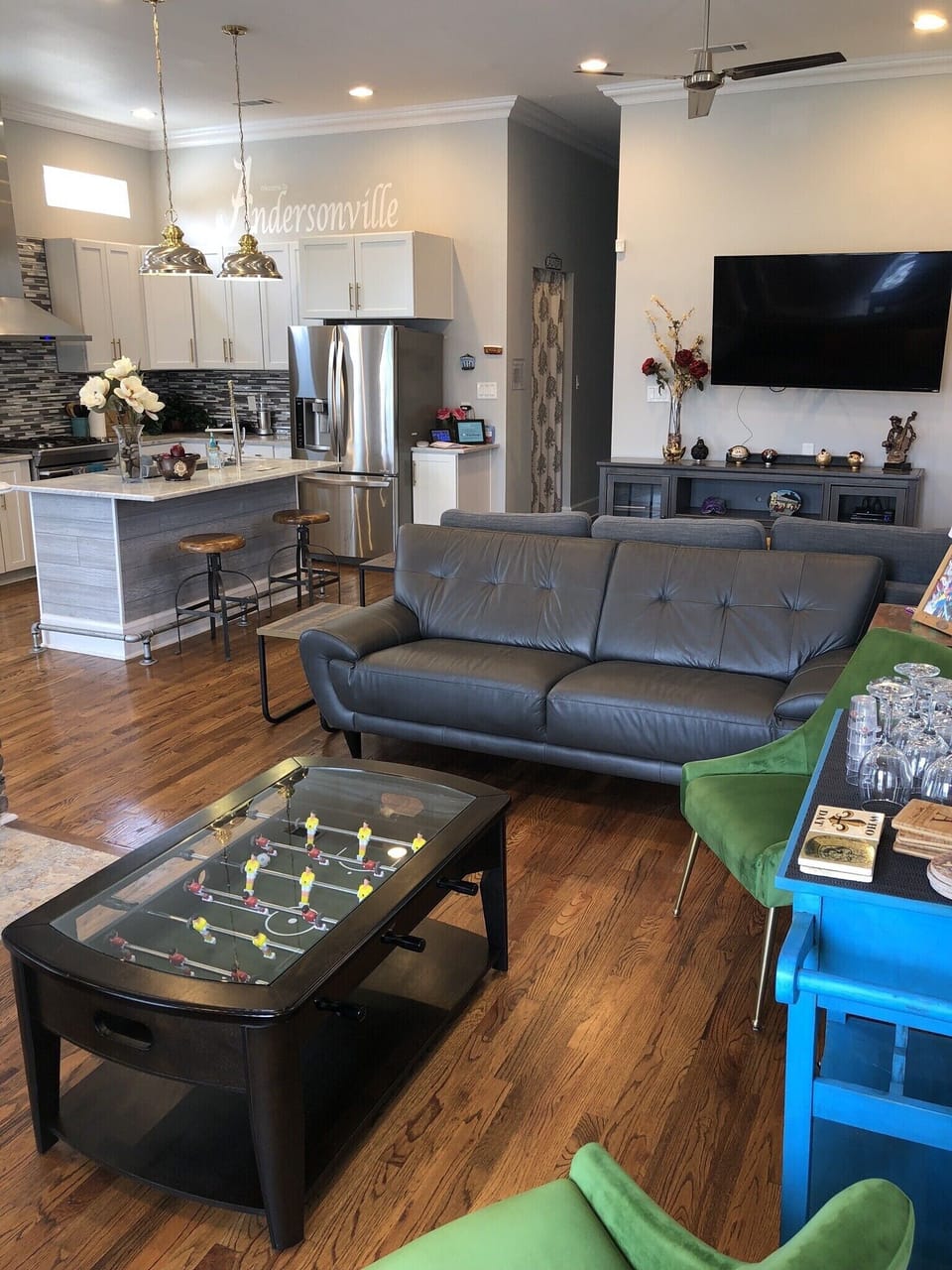 Open Living room with 70" TV, L-shaped sofa and another leather sofa