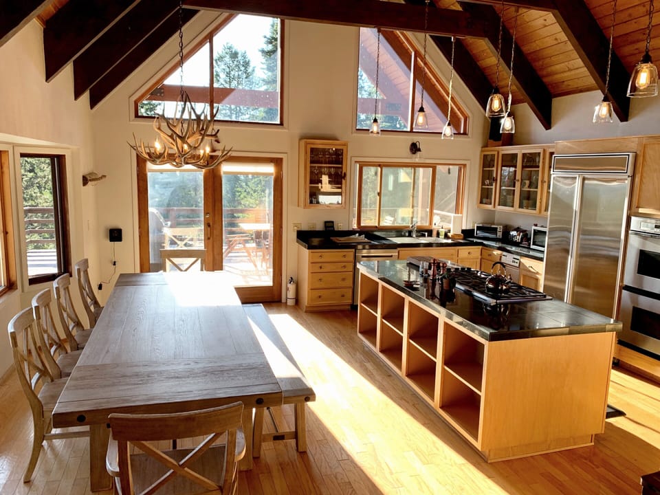 Kitchen and dining area with Teton views and doors out to large deck with grill.