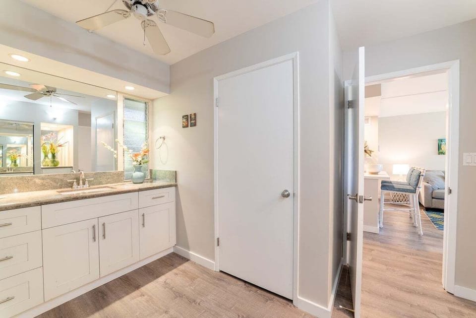 Spacious bathroom with full length mirror, vanity and tub and shower combo