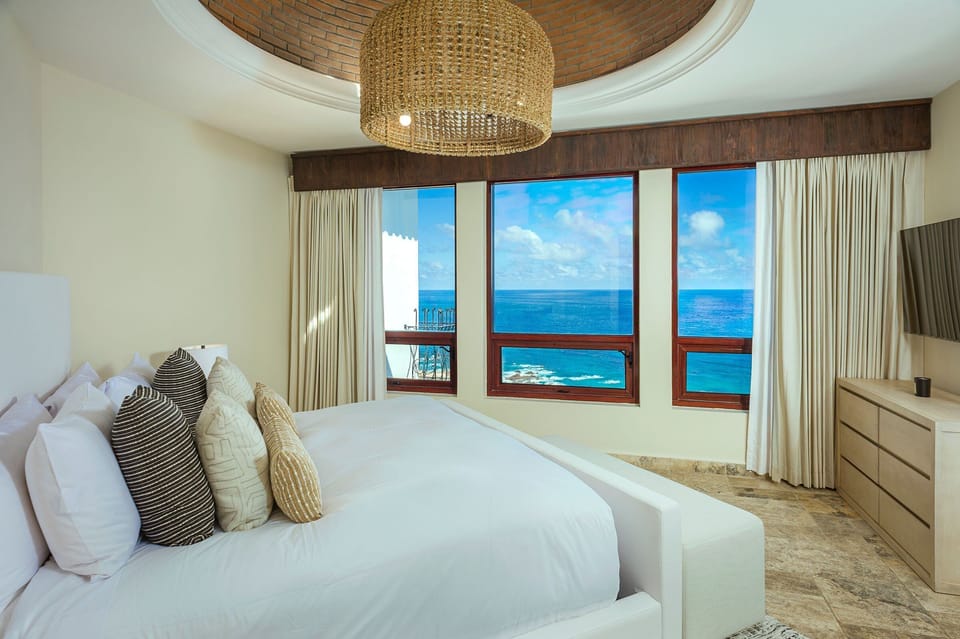 Ocean-view bedroom with a domed brick ceiling and king bed at Casa Rio de Luna, Los Cabos.