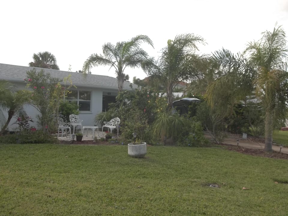 Street side patio, tropical gardens and driveway