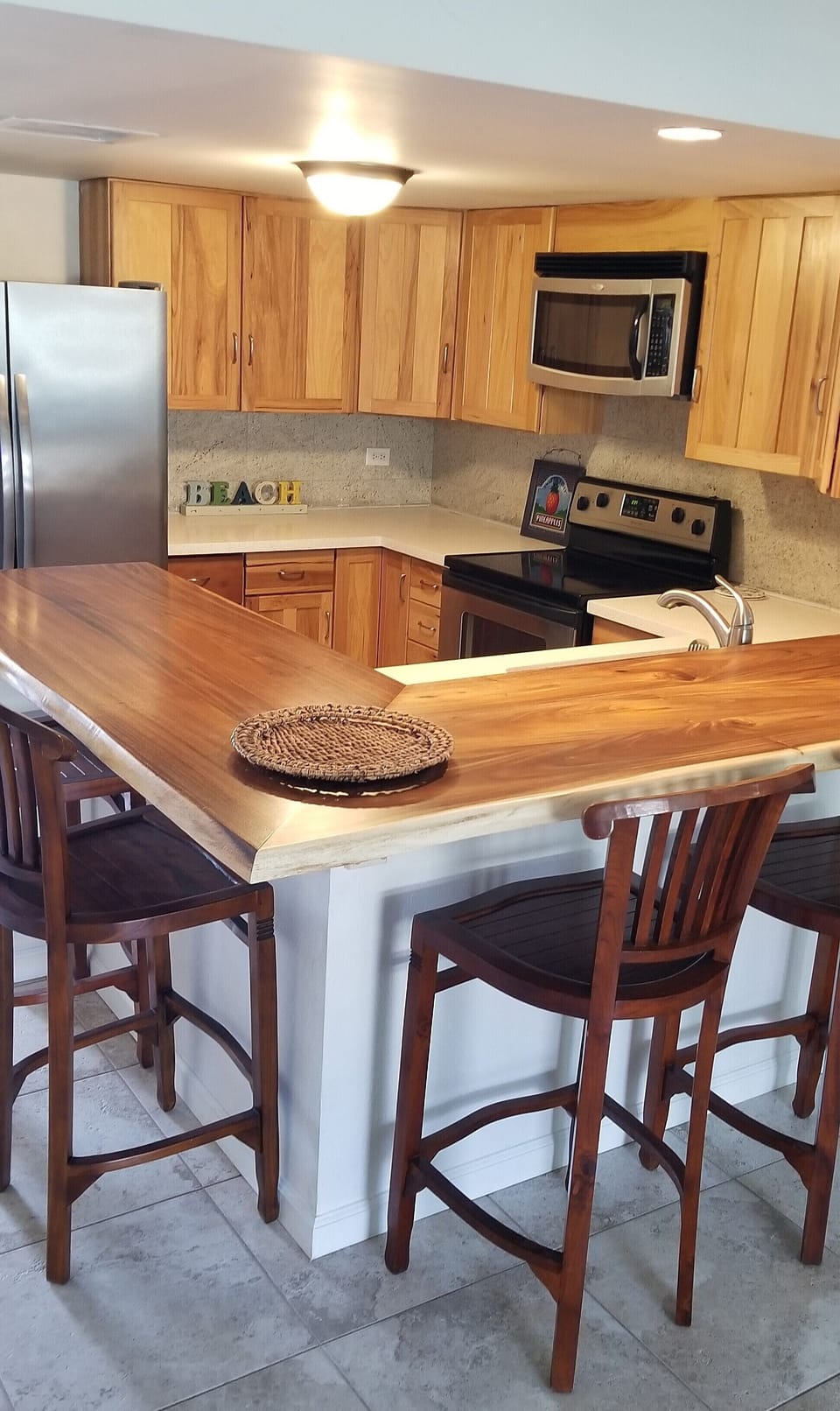 Freshly updated kitchen with quartz counters and custom raw edge wood island