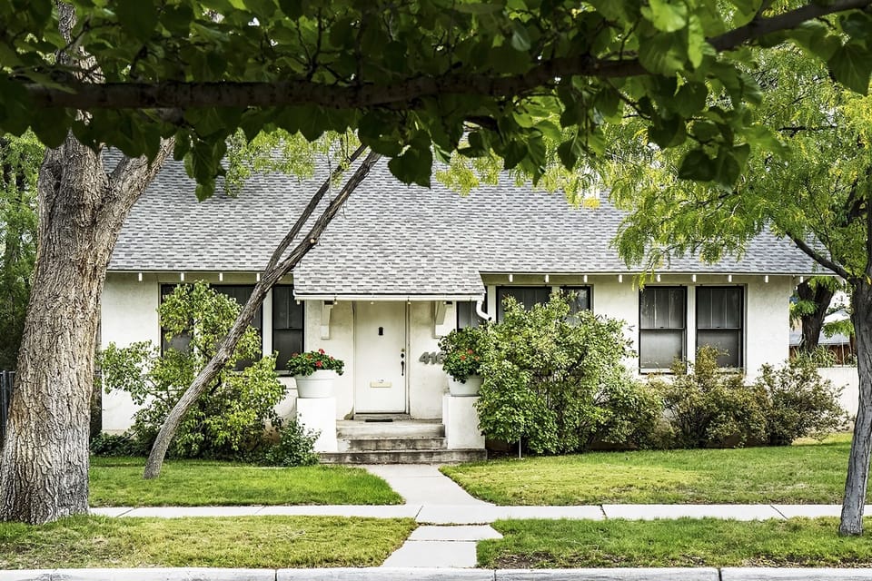 Bungalow style home with large trees