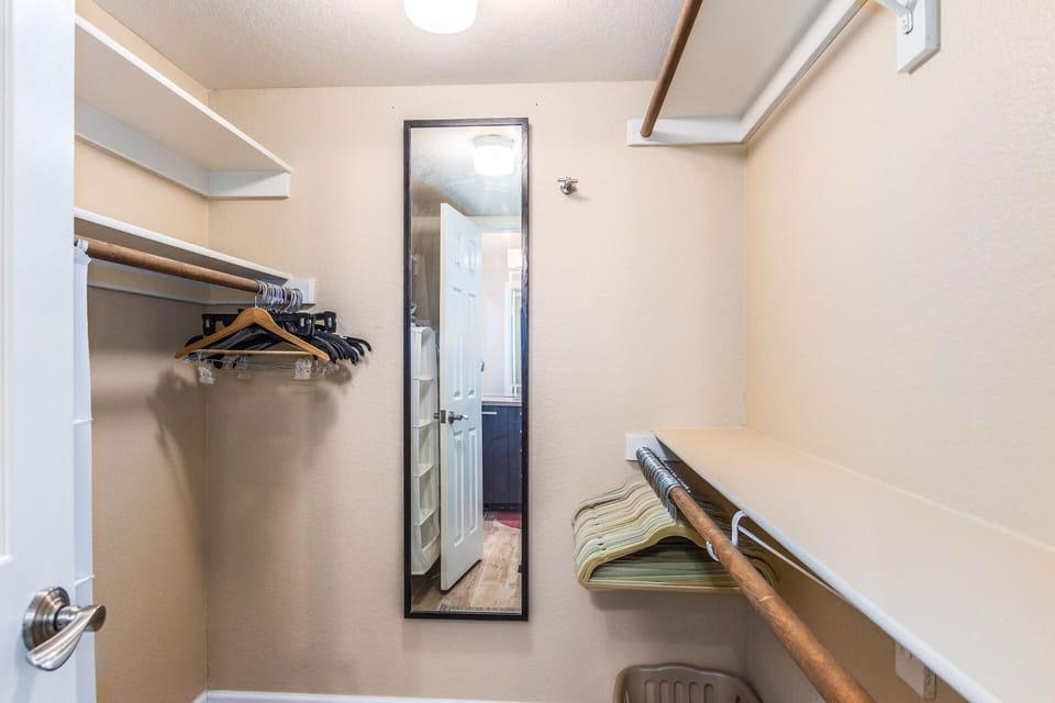 Wood print plank tile flooring flows into the master closet from the master bath.