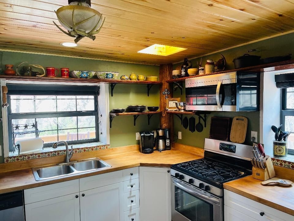 The well-equipped kitchen includes stainless steel appliances & open shelving