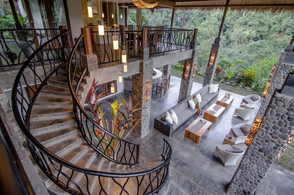 View of upper dining area, stairs and great room with wet bar.