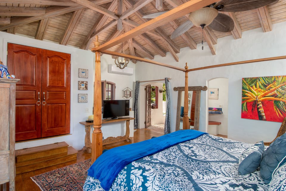 BEDROOM 1: Romantic primary suite w/ high ceilings & a king size four poster bed