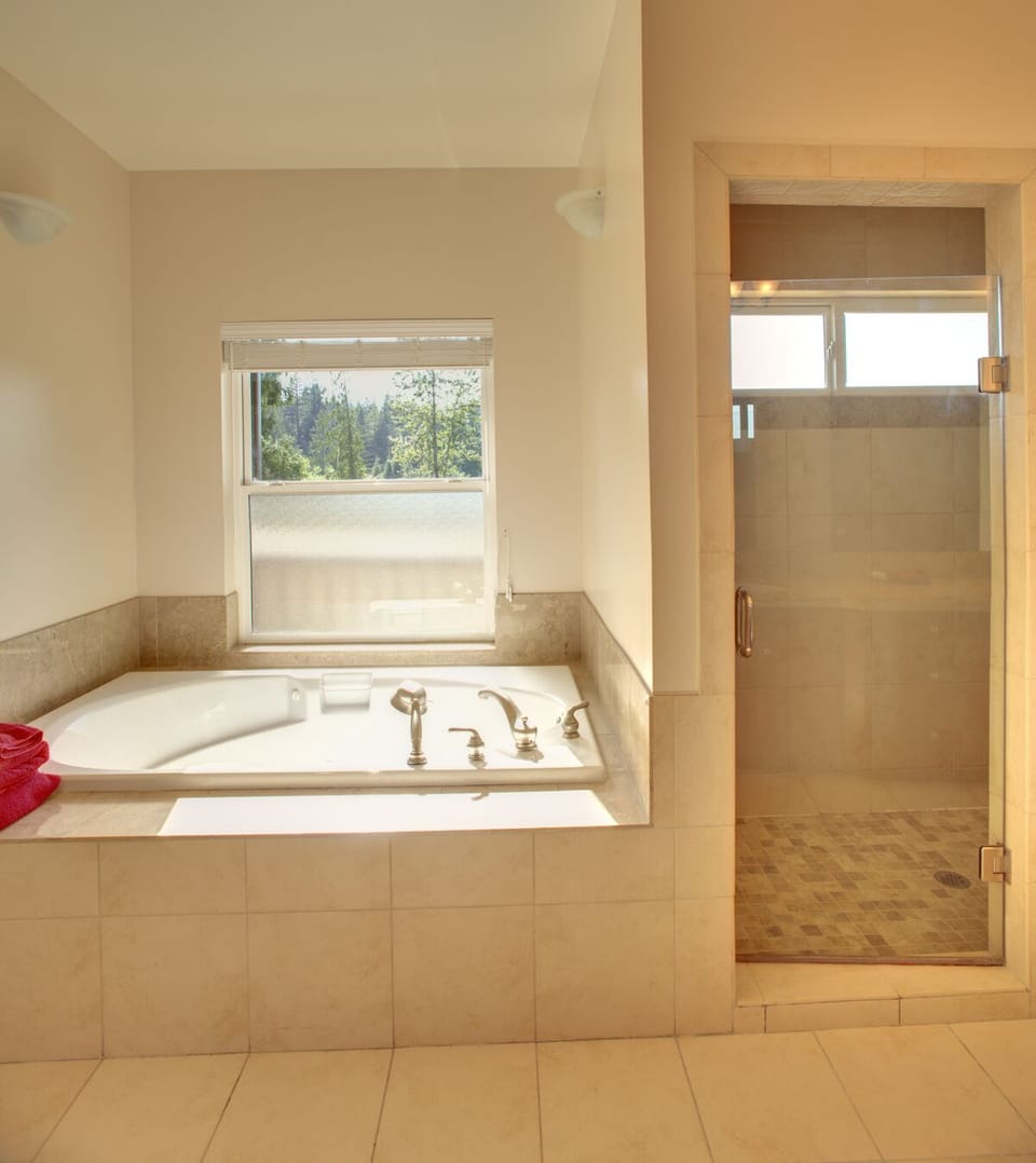 Jetted tub with view of lake in master bathroom.