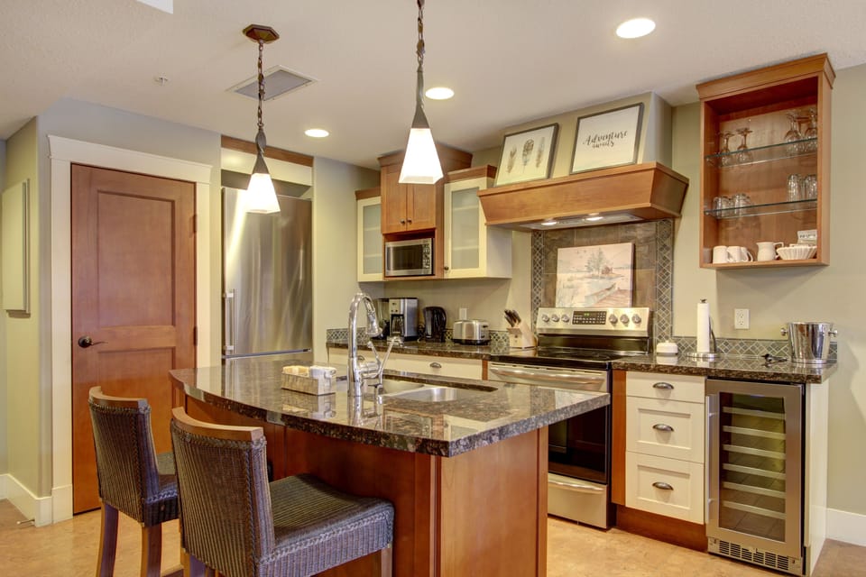 The gourmet, eat-in kitchen is fully stocked and features a wine fridge, and stainless steel appliances.