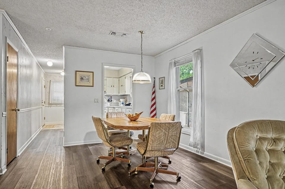 Picture yourself gathering around this welcoming dining table, bathed in natural light from the window. The space flows effortlessly into the kitchen, perfect for your vacation meals.