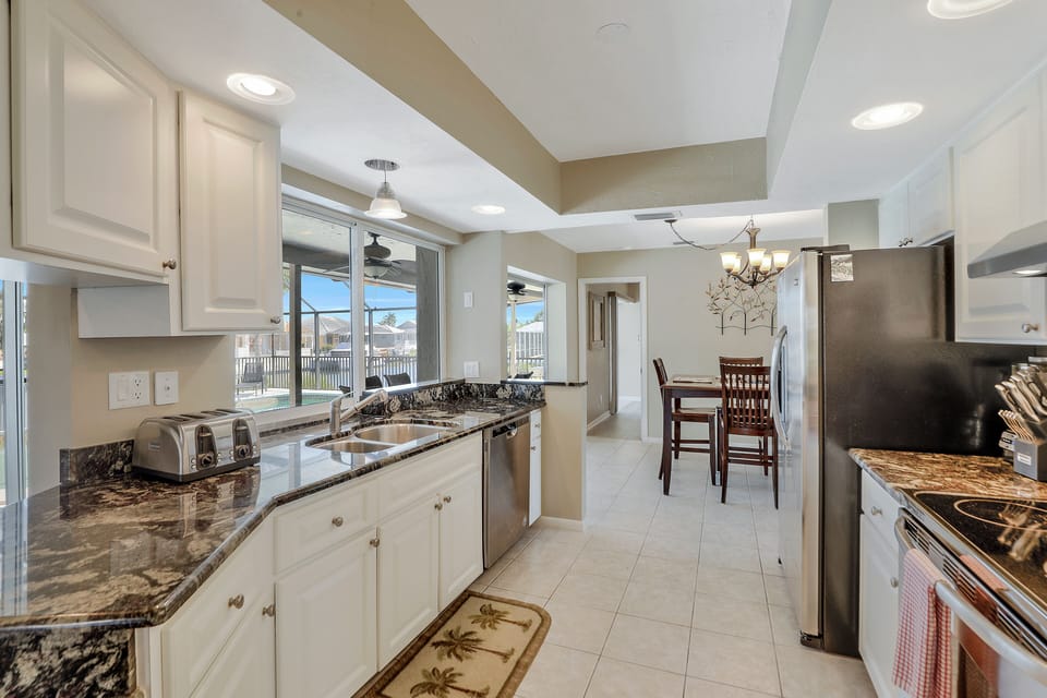 Kitchen with passthrough window overseeing the pool and water canal.