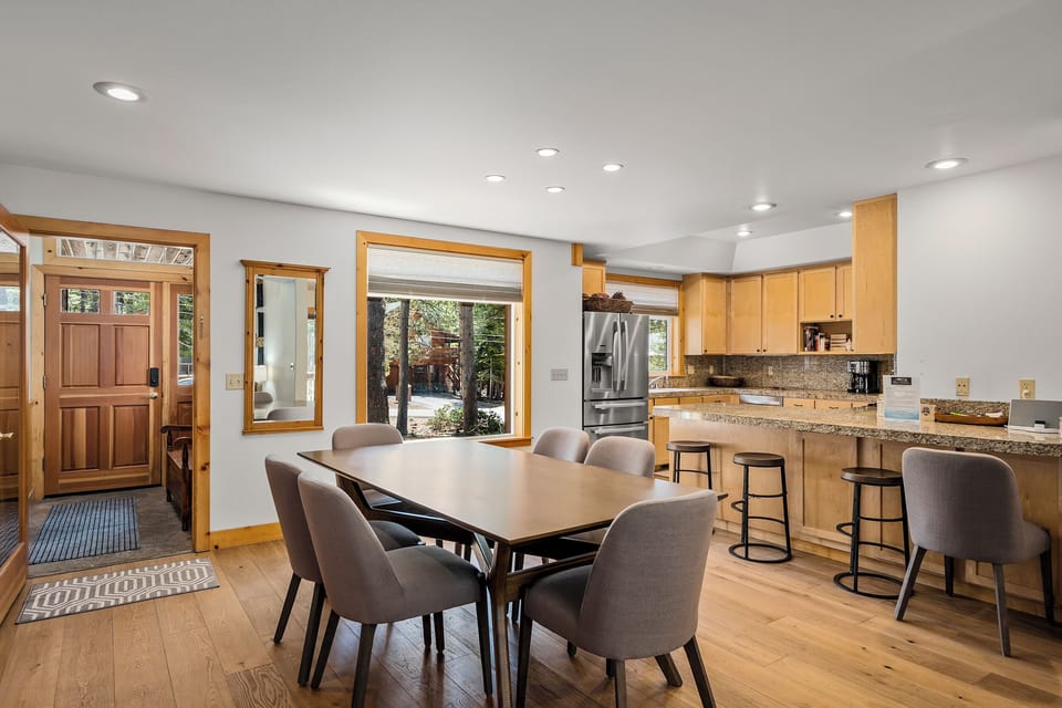 Gather around the table in this open kitchen and dining space, where natural light pours through large windows. Modern appliances and a breakfast bar make meal prep easy and social.