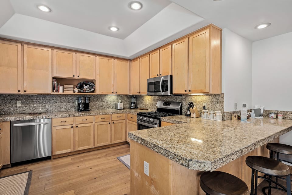 Picture yourself preparing delicious meals in this spacious, fully equipped kitchen with gleaming granite counters, modern appliances, and an inviting island for casual dining and conversation.