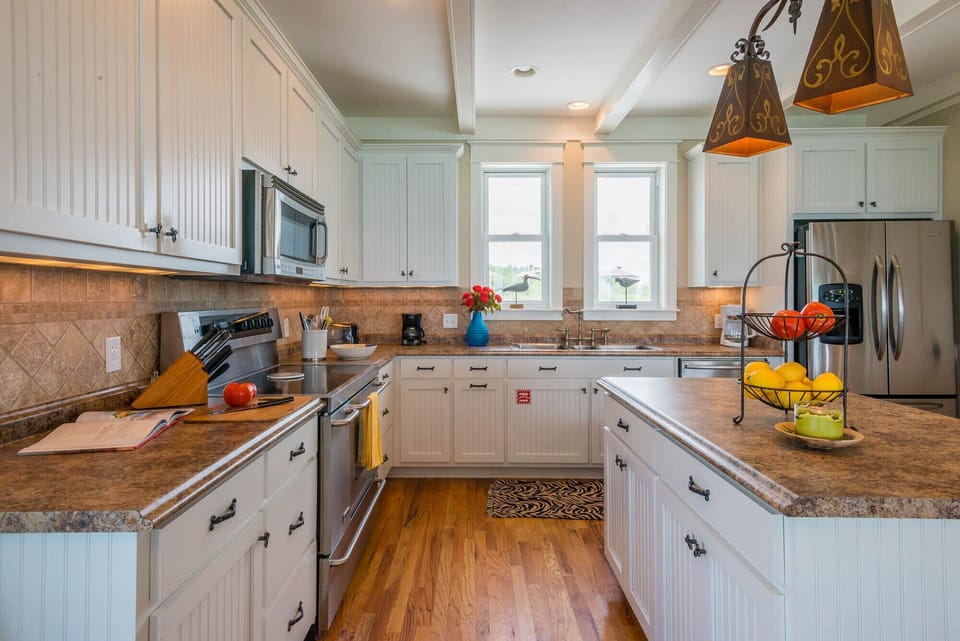 Another view of the kitchen - microwave stove/oven, dishwasher and frig. 
