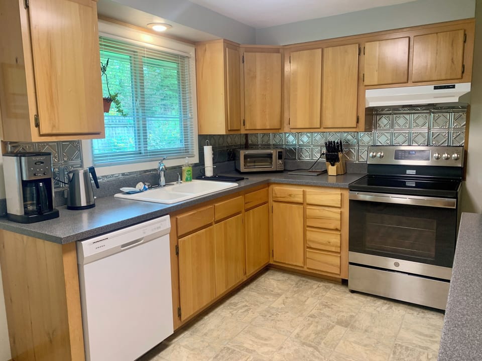 Spacious kitchen with cultured marble countertops and pressed tin backsplash.