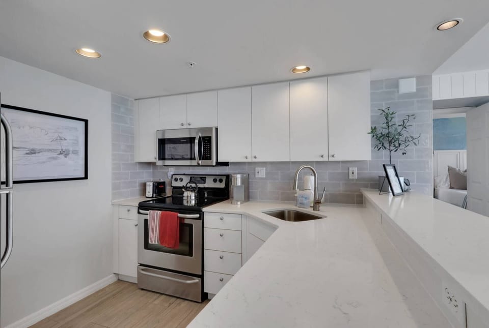 The kitchen has been beautifully remodeled with quartz counters, tile backsplash, and full size stainless appliances.