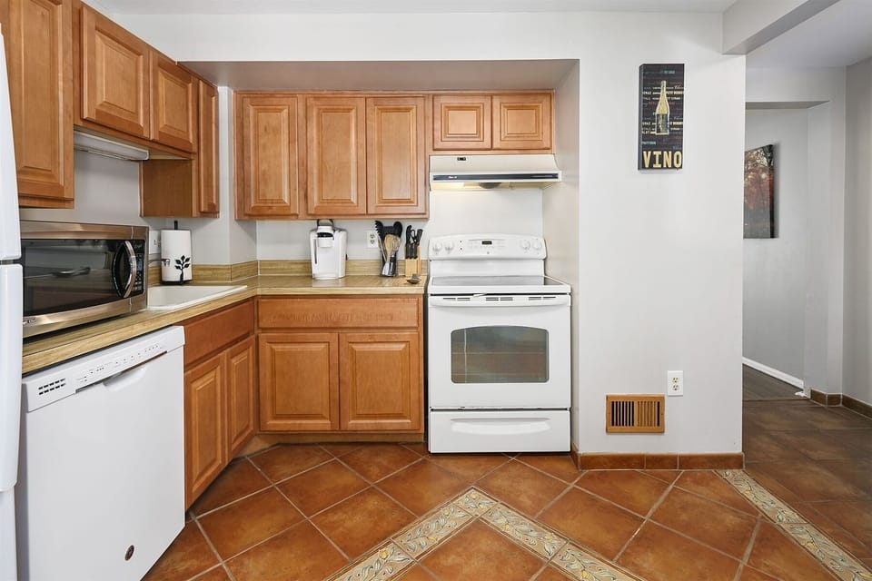Top-of-the-line kitchen appliances include an electric range & dishwasher