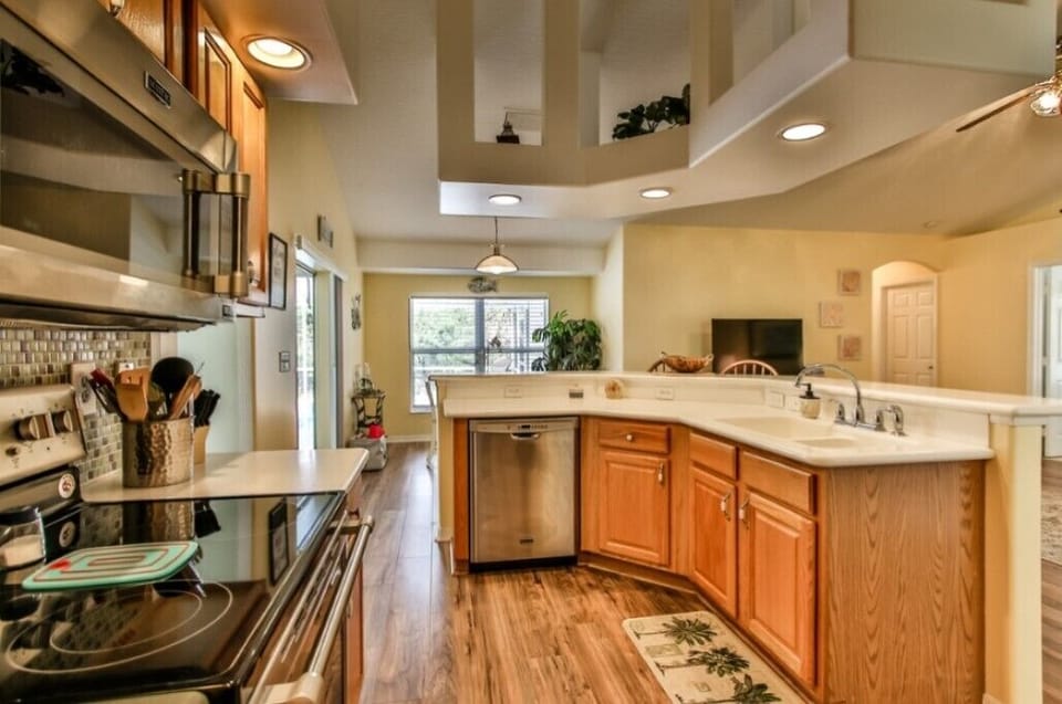 Kitchen with hardwood floors, stainless appliances and a large counter area.