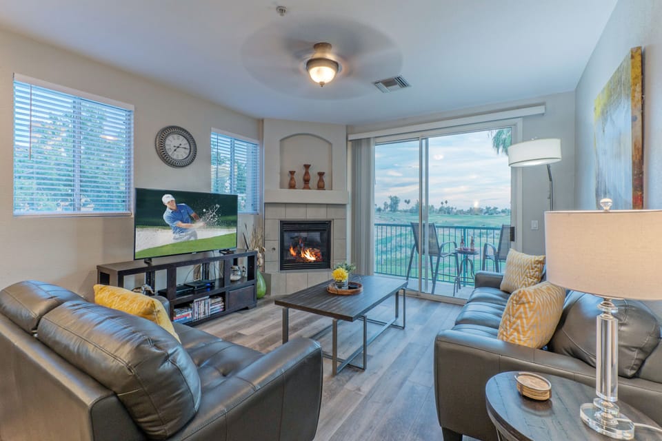 The great room in SUPERSTITION LAKES MANOR has a gas fireplace, large TV and spectacular views of the public golf course.