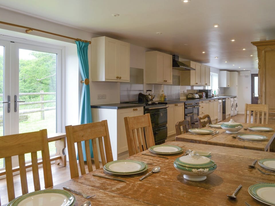 Large kitchen and dining room with French doors to garden | Tutchenor Farmhouse, Patchacott, near Beaworthy