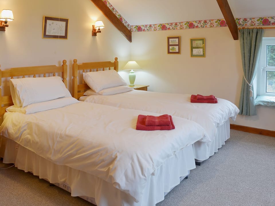 Twin bedroom with sloping and beamed ceiling | The Stables, Carthamartha, near Launceston