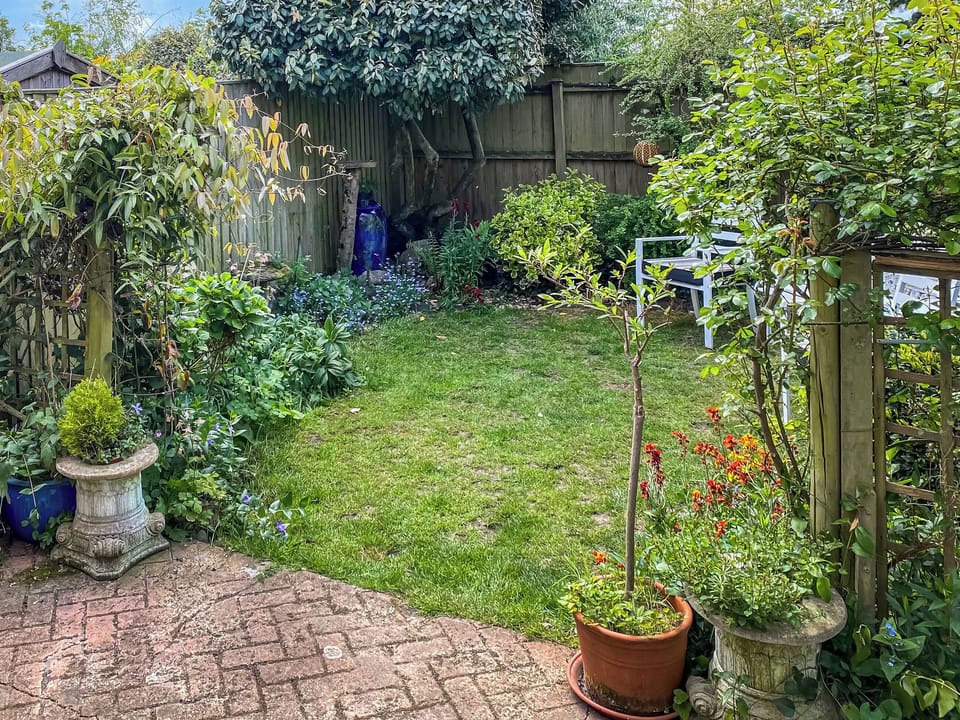 Enclosed garden beyond patio | Overland Cottage, Holt