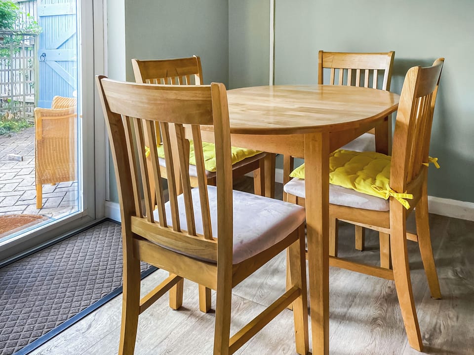 Dining area with four chairs TV is above | Overland Cottage, Holt