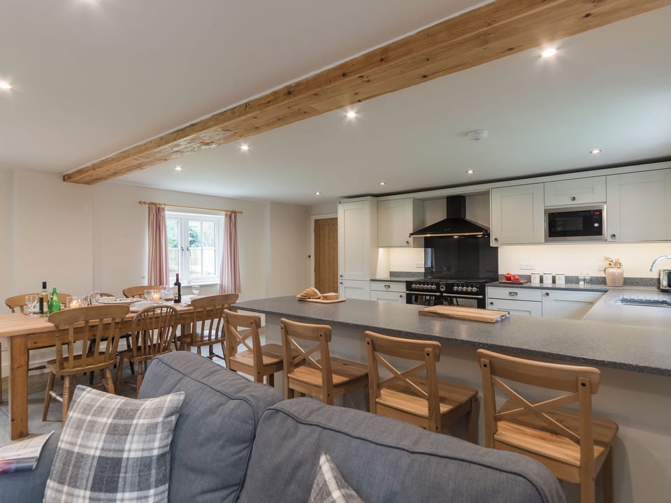 Open plan living space with exposed brickwork and a well-equipped kitchen and dining area | White Lodge Cottage, Carlton Miniott, near Thirsk