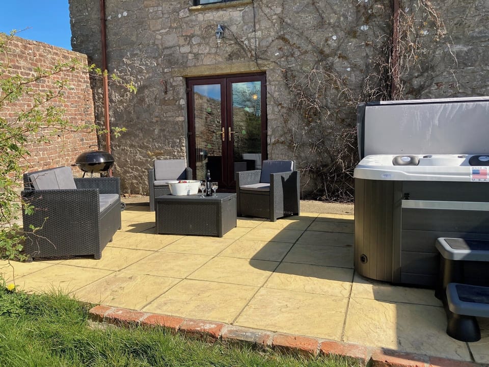 Patio area with hot tub | The Coach House, Trelawnyd, near Prestatyn
