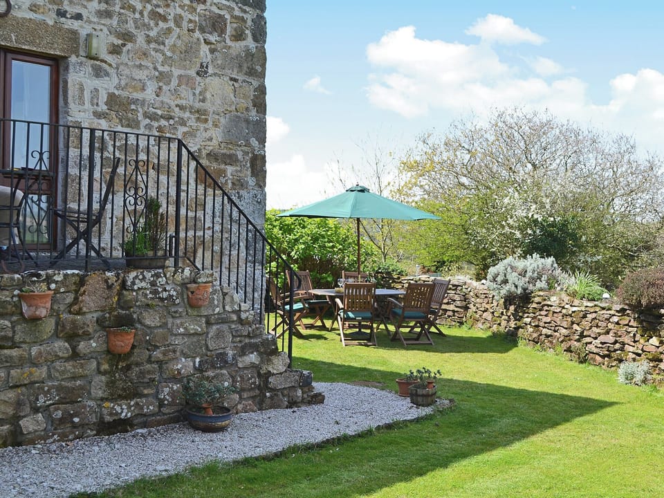 Sone steps lead down from a small patio to the private walled garden | Coachmans Cottage, White Cross, near Newquay