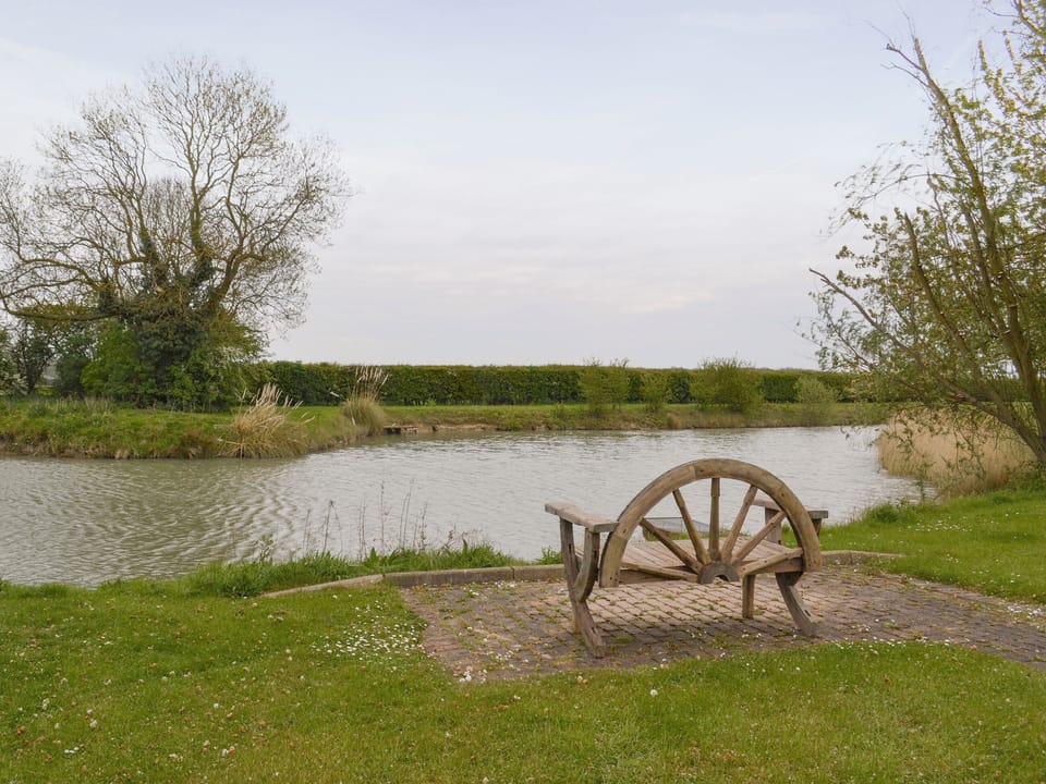 Seating area beside the well-stocked fishing lake | Wallrudding Farm Cottage, Doddington, near Lincol