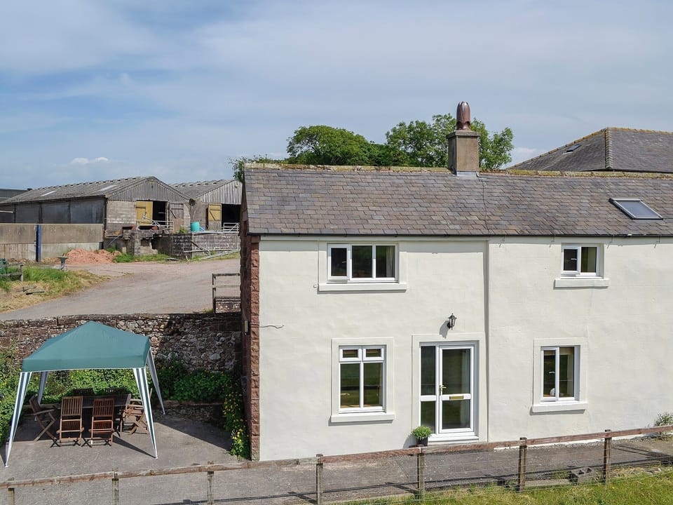 Whitewashed farmhouse with sitting area | Farm Cottage - Springfield Farm Cottages, Bigrigg, near Egremont