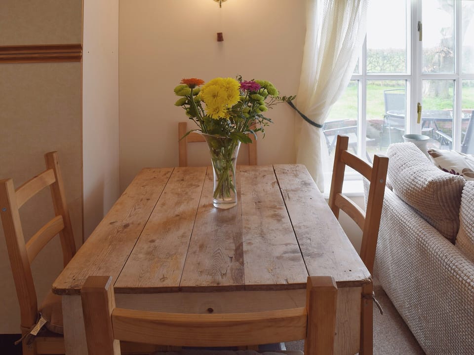 A farmhouse kitchen style dining table between the living and kitchen area has great views over the countryside | Blueberry Cottage, Debenham, near Framlingham