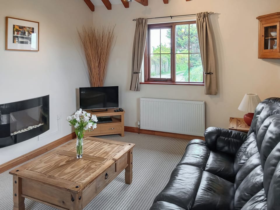 Beamed living room with contemporary electric fire | Beckaveans Stable - Beckaveans, Jacobstow, near Bude