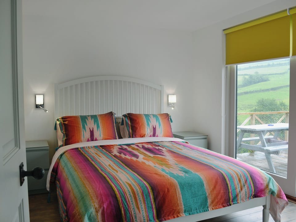 Comfortable double bedroom with doors leading to patio | The Shed with a View, Cadbury, near Crediton
